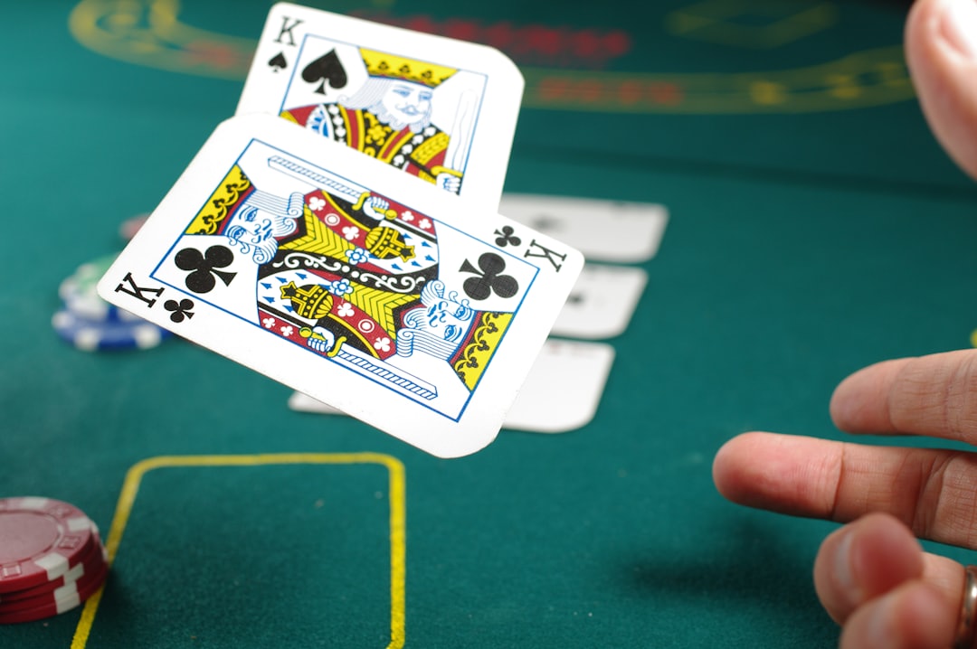 Pemain sedang memegang kartu poker di meja permainan